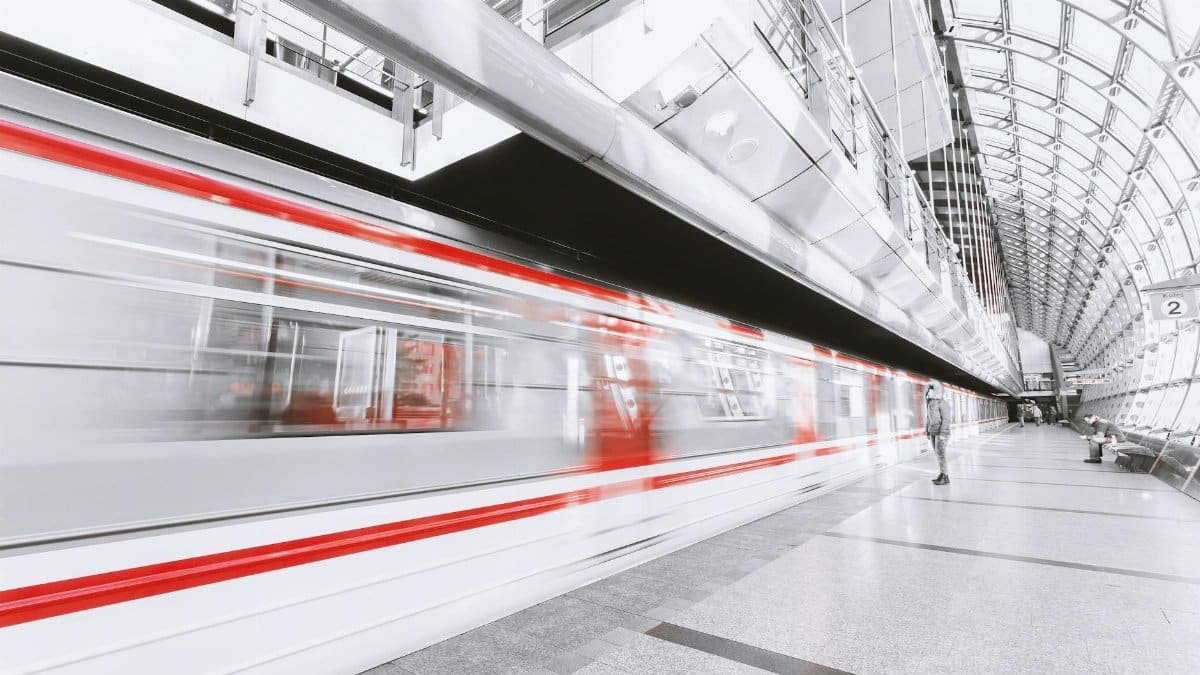 Blurred high-speed train in a sleek modern station, capturing urban commuting and motion.