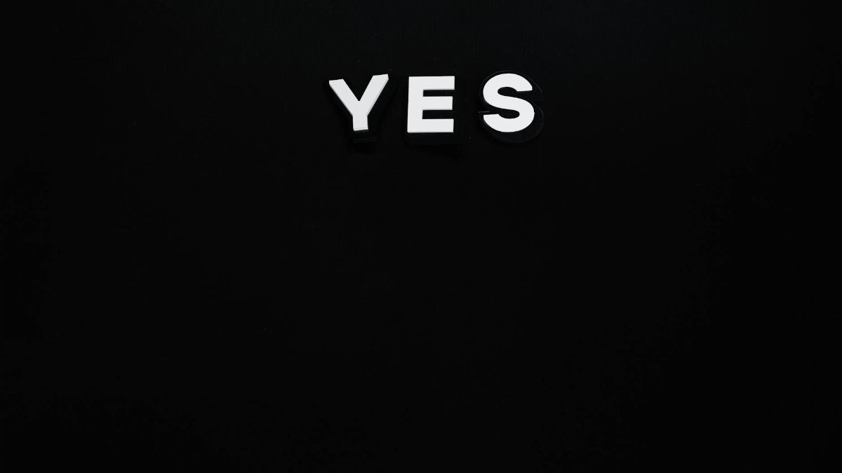 Bold white 'YES' letters on a minimalist black background, conveying positivity and affirmation.