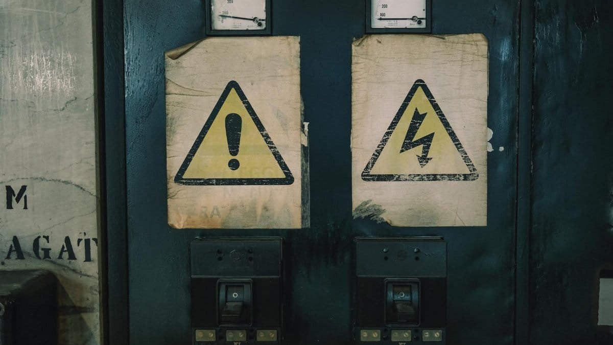 Close-up of industrial warning signs on an aged electrical panel.