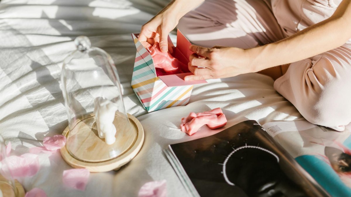 A person unboxes a gift among pink petals, promoting elegance and luxury.