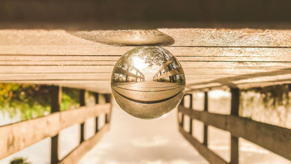 Artistic reflection of a bridge captured in a glass sphere, showcasing a creative perspective.