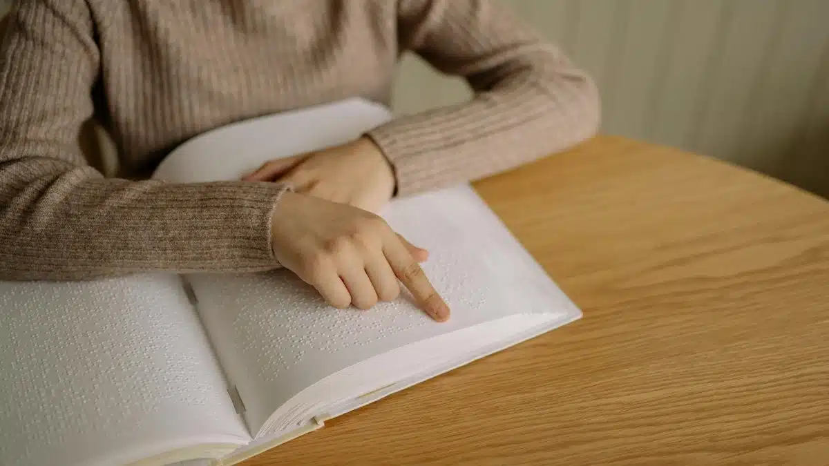 Close-up view showing a hand reading Braille text, symbolizing accessibility and inclusion.