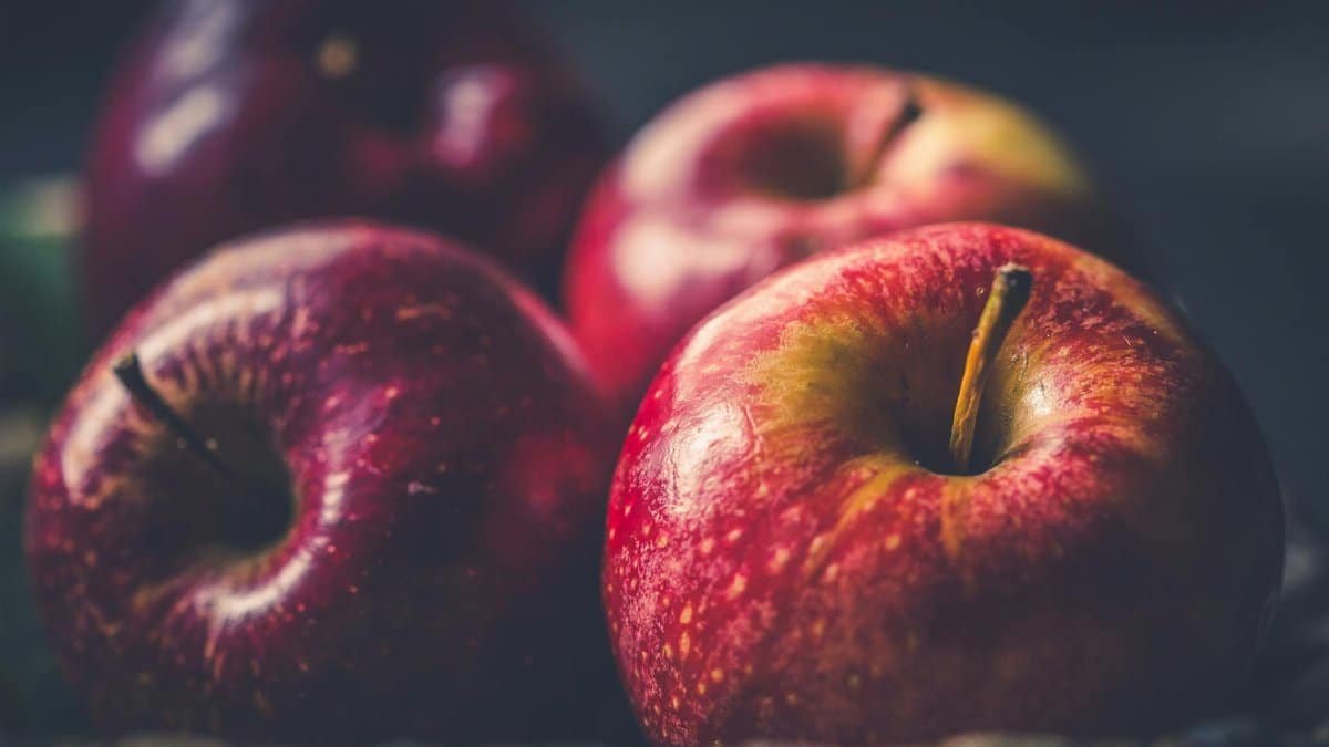 Vibrant red apples glistening with freshness in a close-up view.