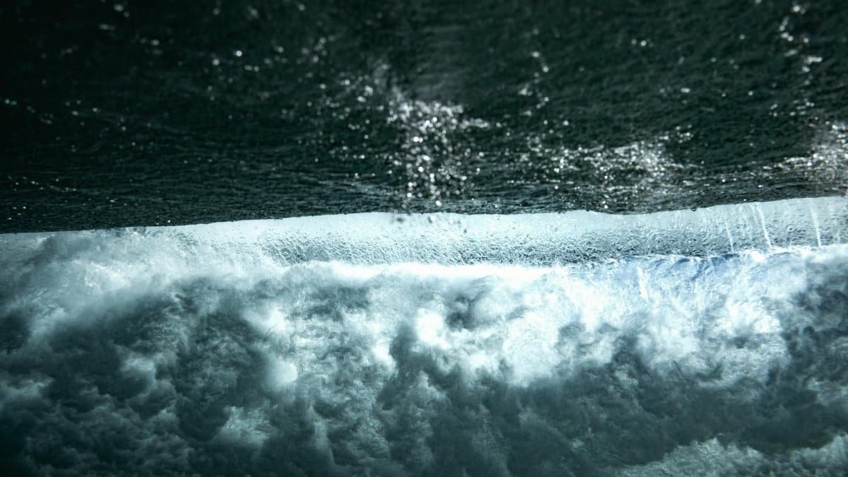 Captivating close-up of an underwater wave capturing the dynamic flow and textures of the ocean.