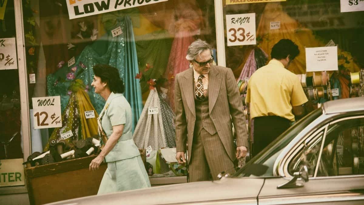 Retro-styled shoppers pass a vintage store in a classic city setting. Nostalgic vibe.