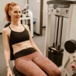 Woman performing leg workout in gym, showcasing fitness and health lifestyle.