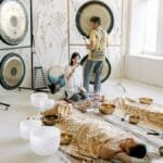 A serene indoor sound bath session with gongs and singing bowls promoting relaxation and wellness.