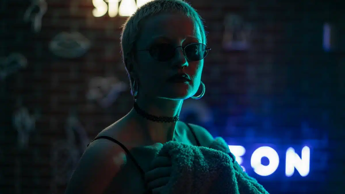 Backlit portrait of a fashionable woman in neon lighting, exuding a stylish and edgy vibe.
