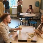 Colleagues enjoying pizza and coffee during a relaxed office lunch break.