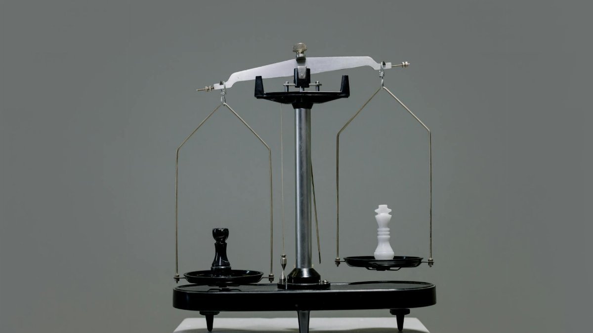 Chess pieces balanced on a scale depicting equality or strategy in decision making.