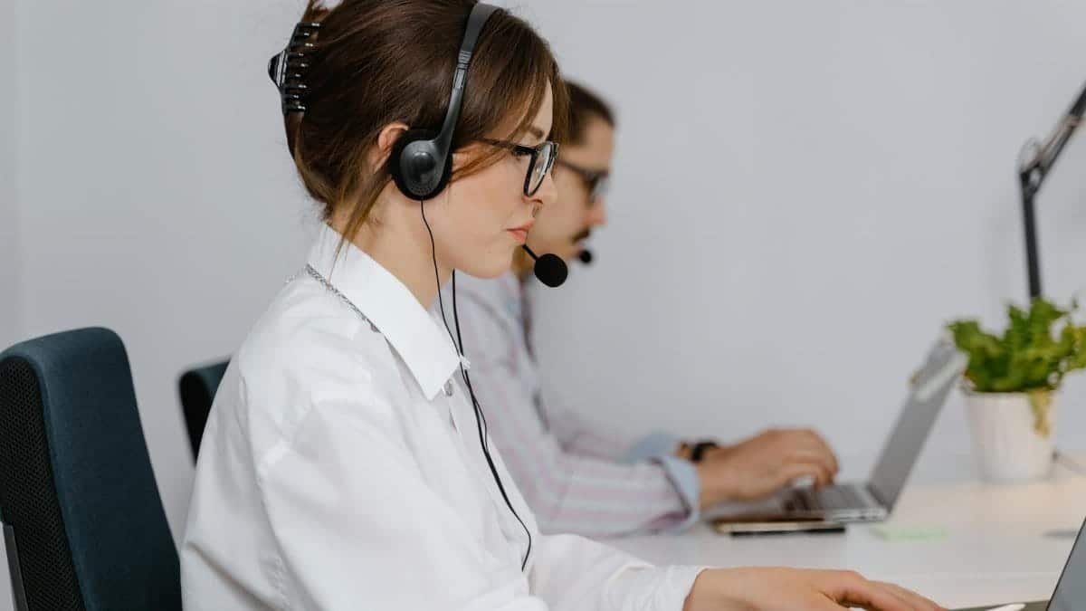 Customer service agents working at call center with headsets, focused on providing support.