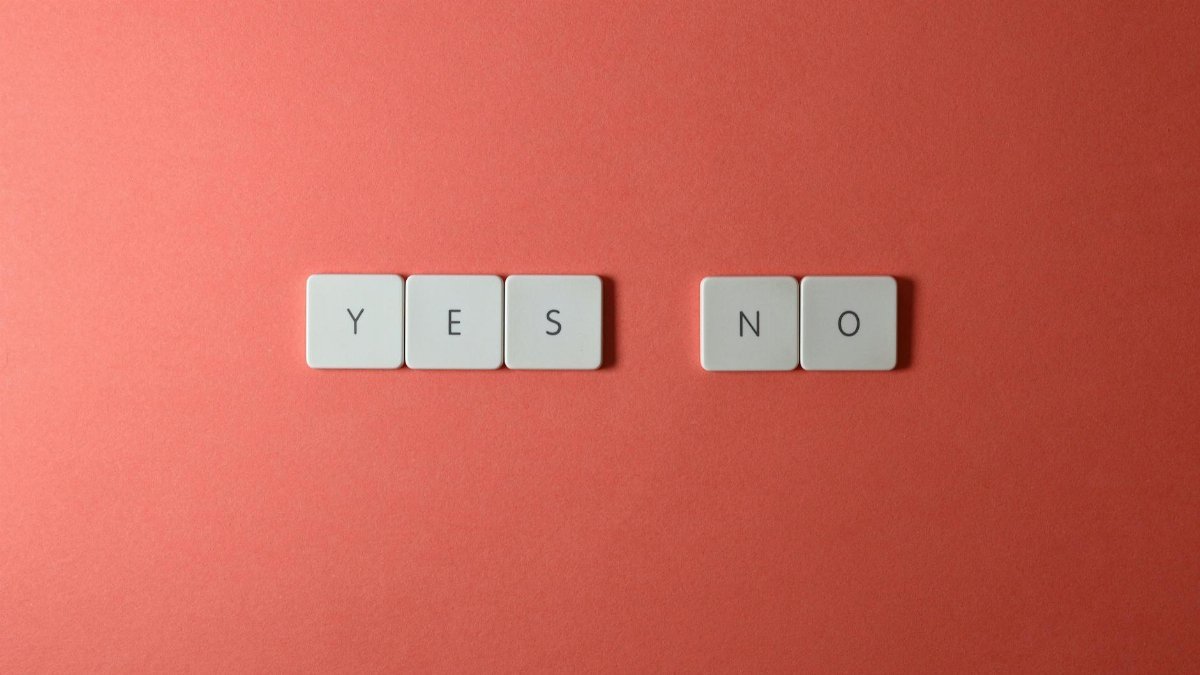 A conceptual image featuring 'yes' and 'no' text on white tiles against a red background, perfect for decision-making themes.