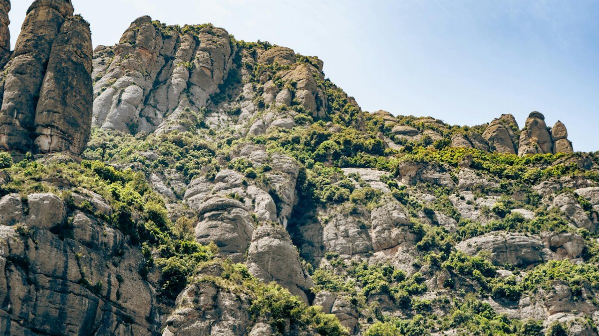 Breathtaking view of the Montserrat mountains' unique rock formations under clear blue skies.
