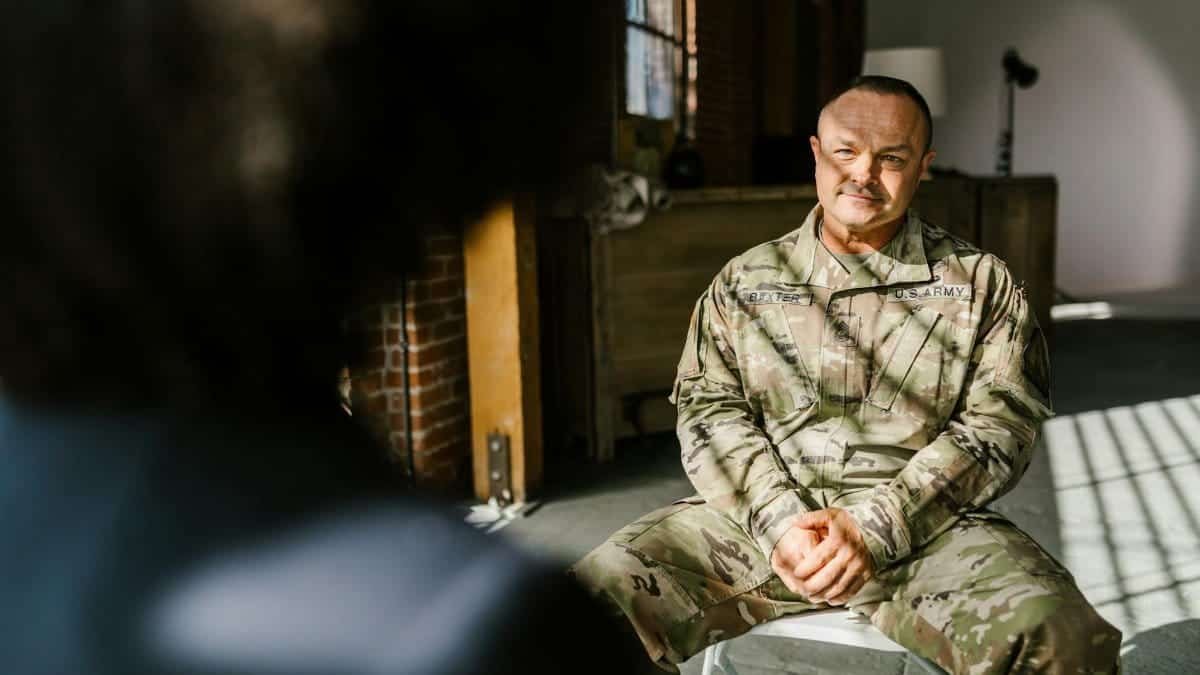 A U.S. Army soldier sits in therapy discussing mental health recovery.