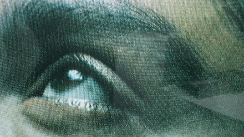 Detailed view of a human eye seen through screen texture, creating a unique visual effect.