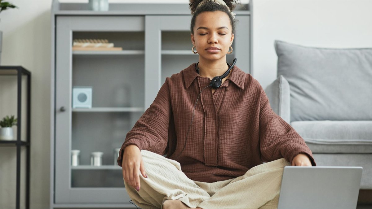 A serene woman practicing meditation at home, promoting relaxation and wellness.