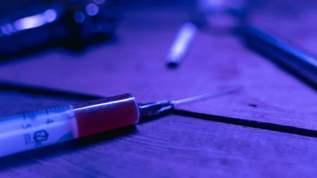 A close-up of a syringe with a dark and moody tone, symbolizing addiction and treatment.
