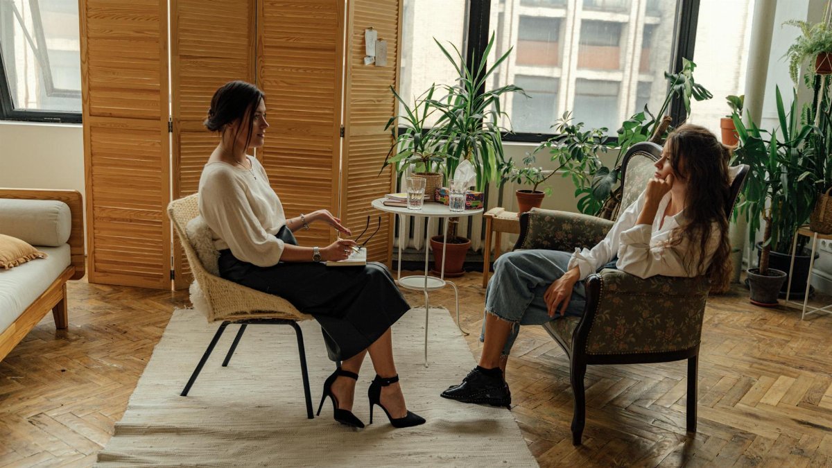 Two women sit in a therapy session, creating a tranquil and professional environment.