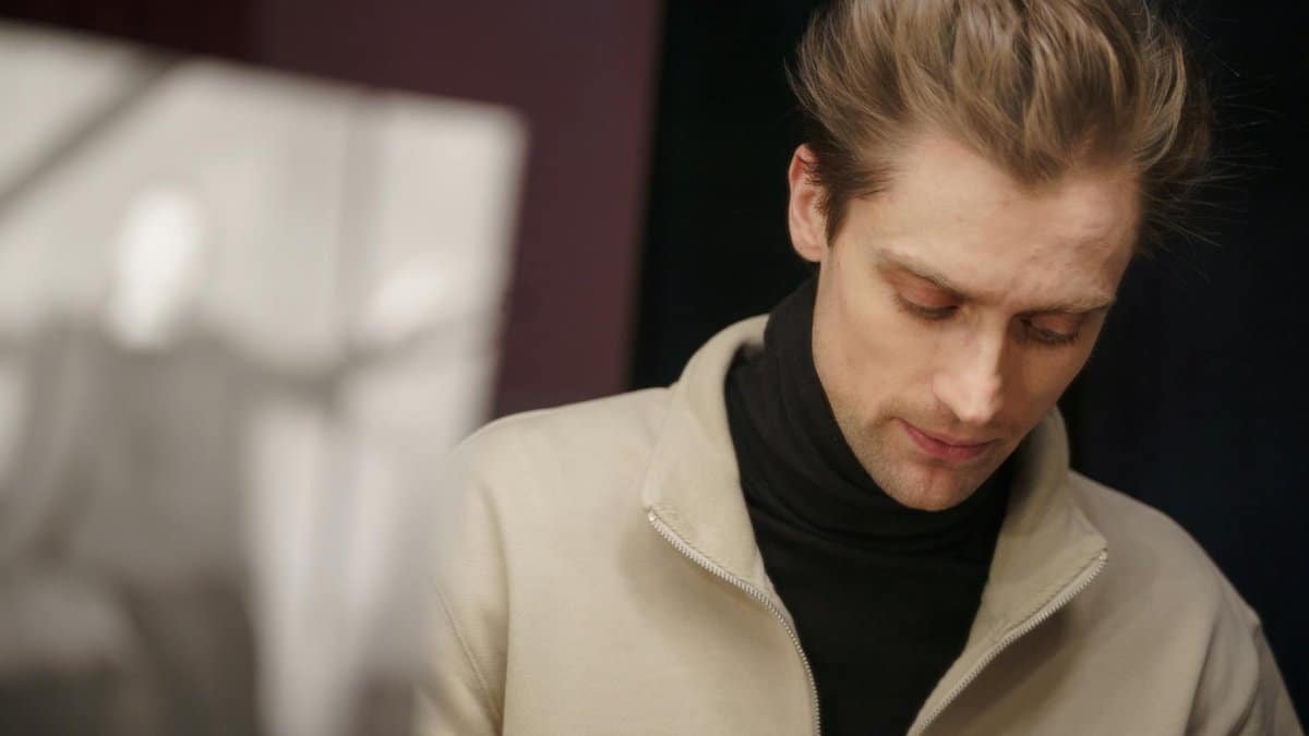 A thoughtful actor in a theater setting, deeply engaged in reviewing his script backstage.