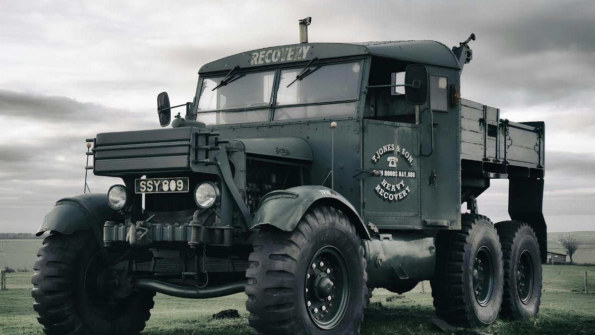 A historic military recovery truck parked in a countryside setting, showcasing its vintage charm.