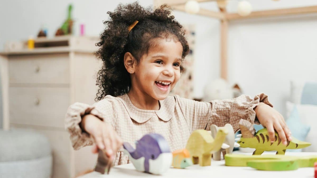 A joyful young girl playing with wooden toys, showcasing pure childhood happiness.