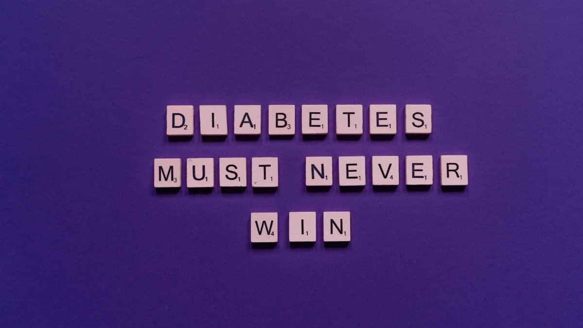 Tile letters on purple background spelling 'Diabetes Must Never Win' for awareness.
