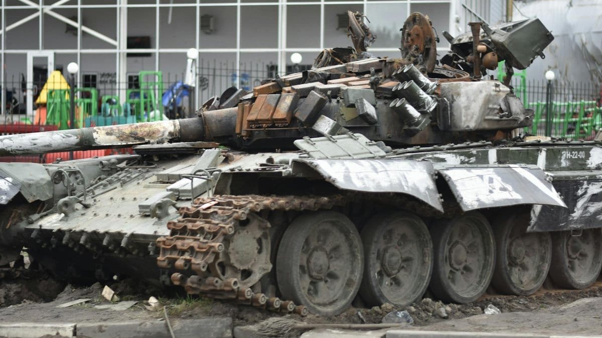 A destroyed military tank in an urban environment showcasing war damage.