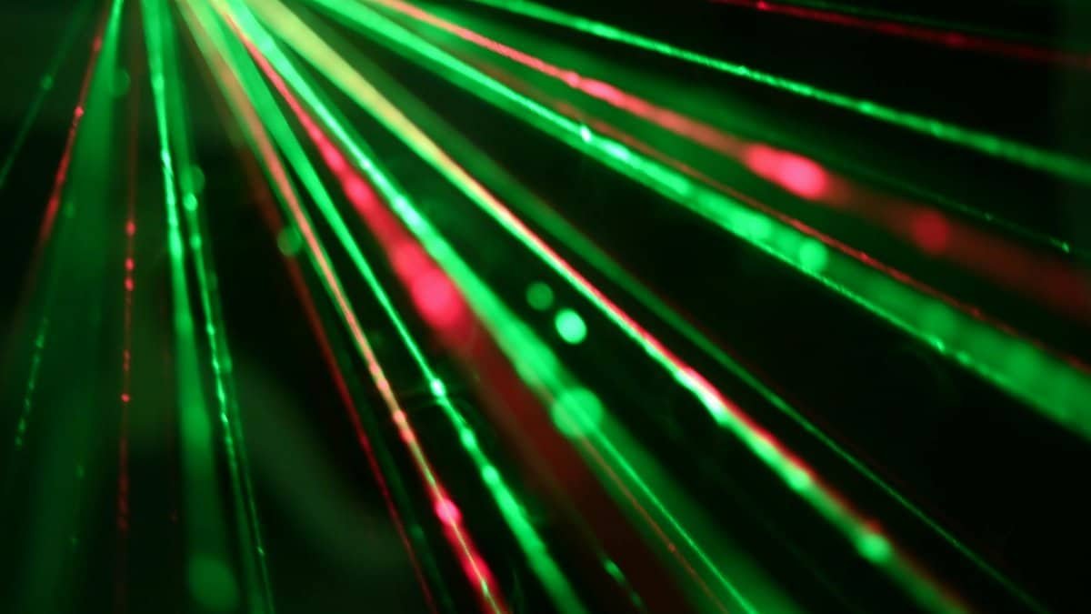 Dynamic display of red and green laser beams creating an abstract and vibrant visual effect.