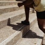A man running up stone stairs outdoors, showcasing fitness and urban exercise.