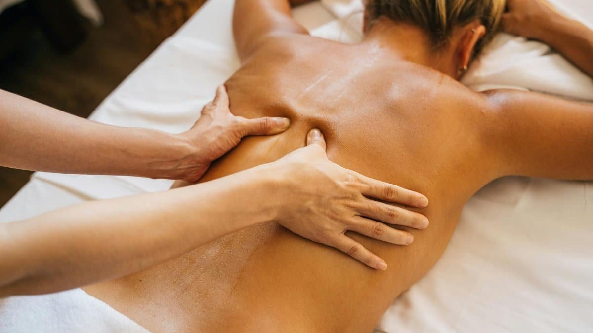 Close-up of a relaxing massage therapy session at a spa with focus on back and hands.