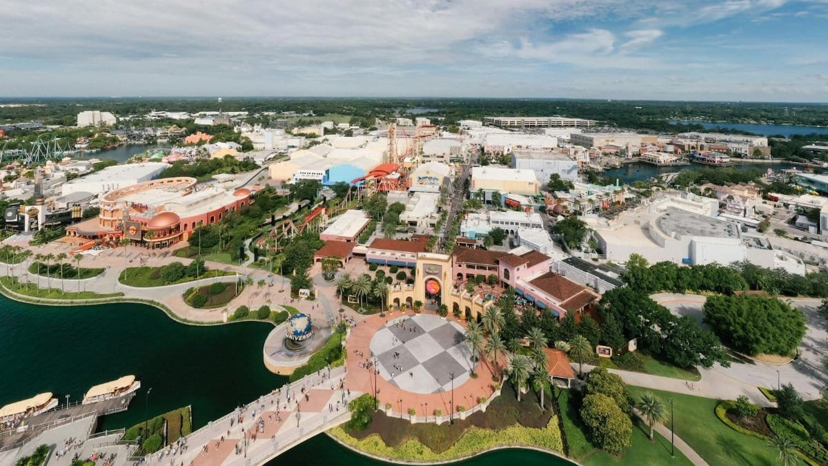Aerial shot showcasing the vibrant theme park layout of Universal Studios Orlando with lush greenery and blue skies.
