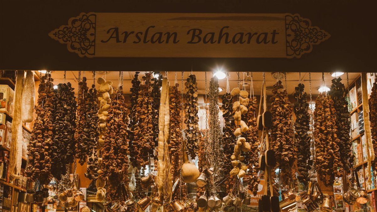 An array of dried spices and herbs hanging in a traditional spice market stall, creating a rich and aromatic scene.