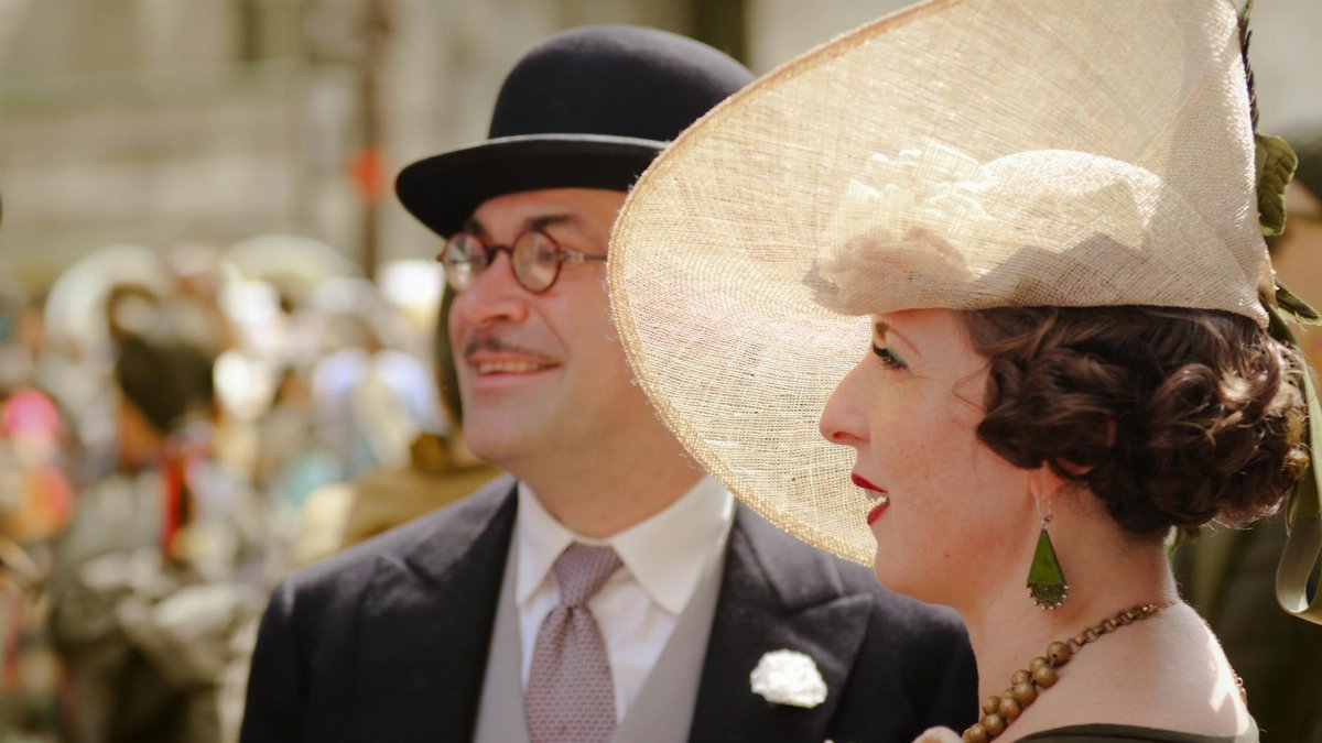A couple in vintage attire attends the Easter Parade in New York City, exuding classic style and elegance.