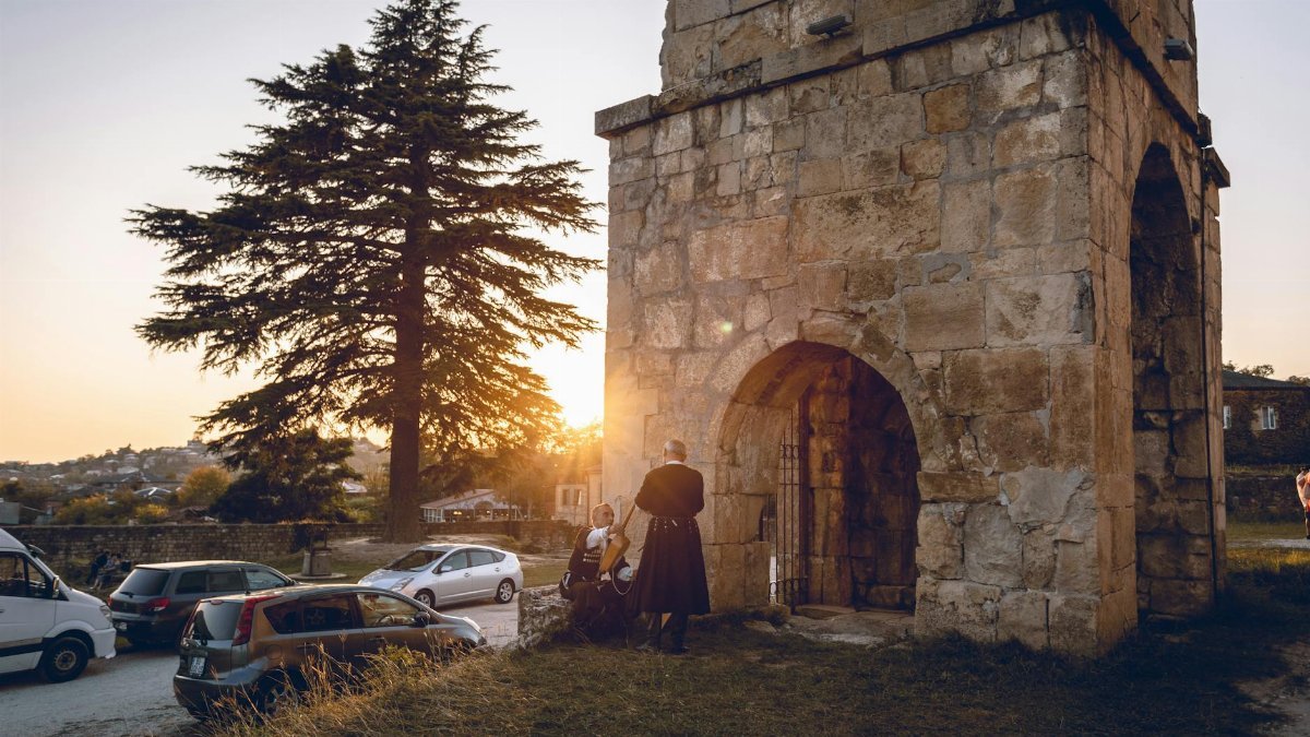 Stone structure in Kutaisi, Georgia, with sunset backdrop, showcasing historical architecture.