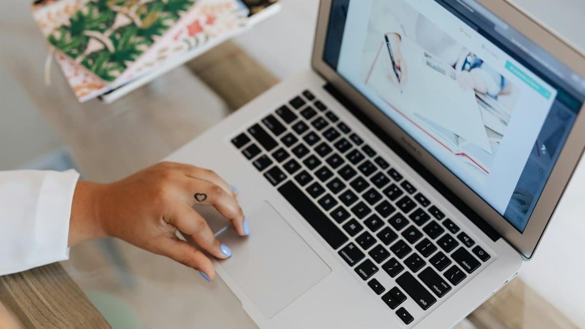 Close-up of a person using a laptop at a desk, focusing on technology and efficiency.