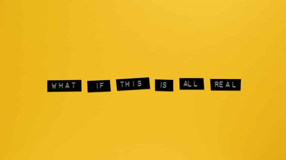 Minimalist text on vibrant yellow backdrop reading 'What if this is all real.'