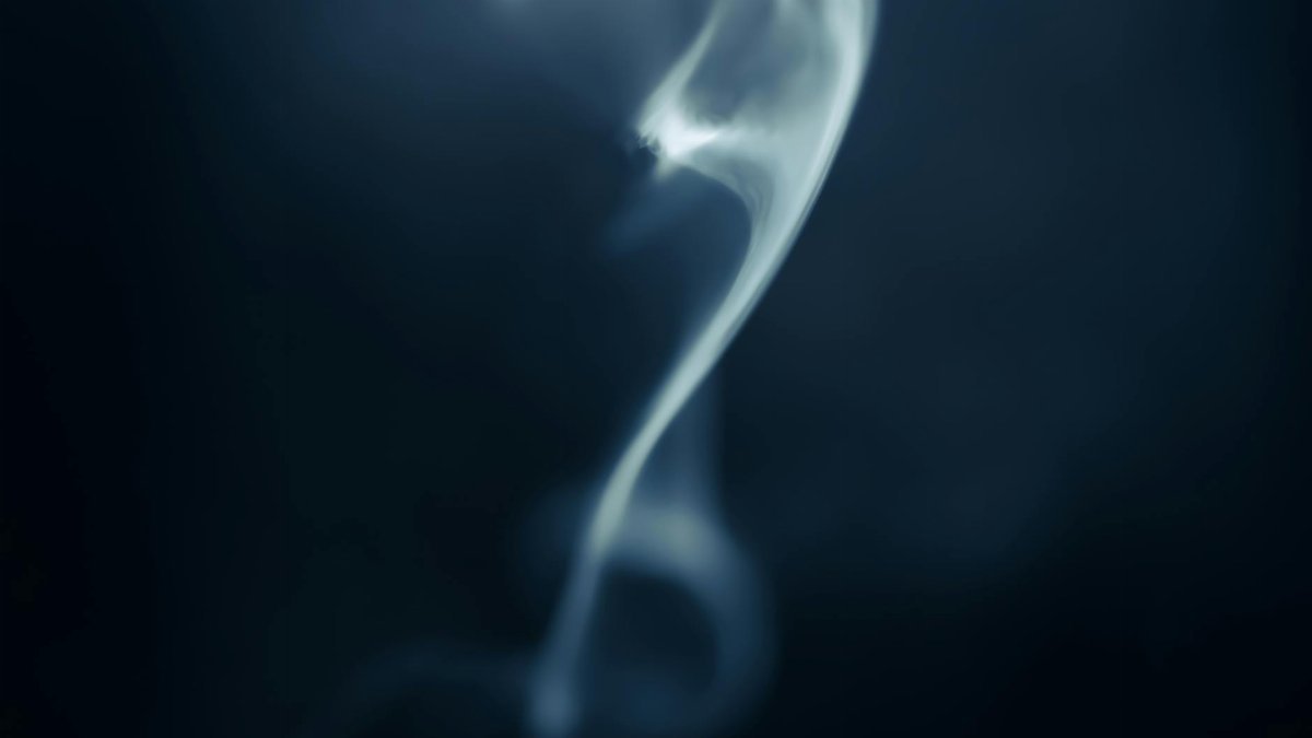 Enchanting abstract smoke swirl against a dark background, highlighting dynamic movement and contrast.