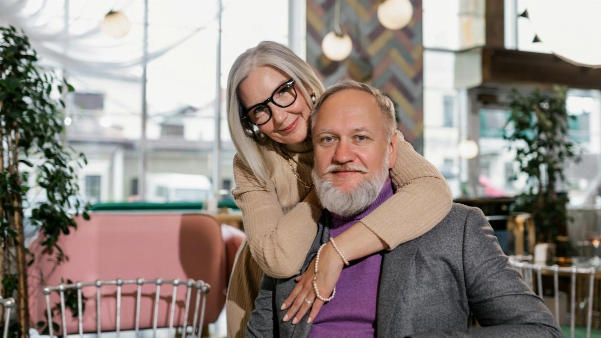 Charming elderly couple embracing in a stylish café, radiating love and warmth.