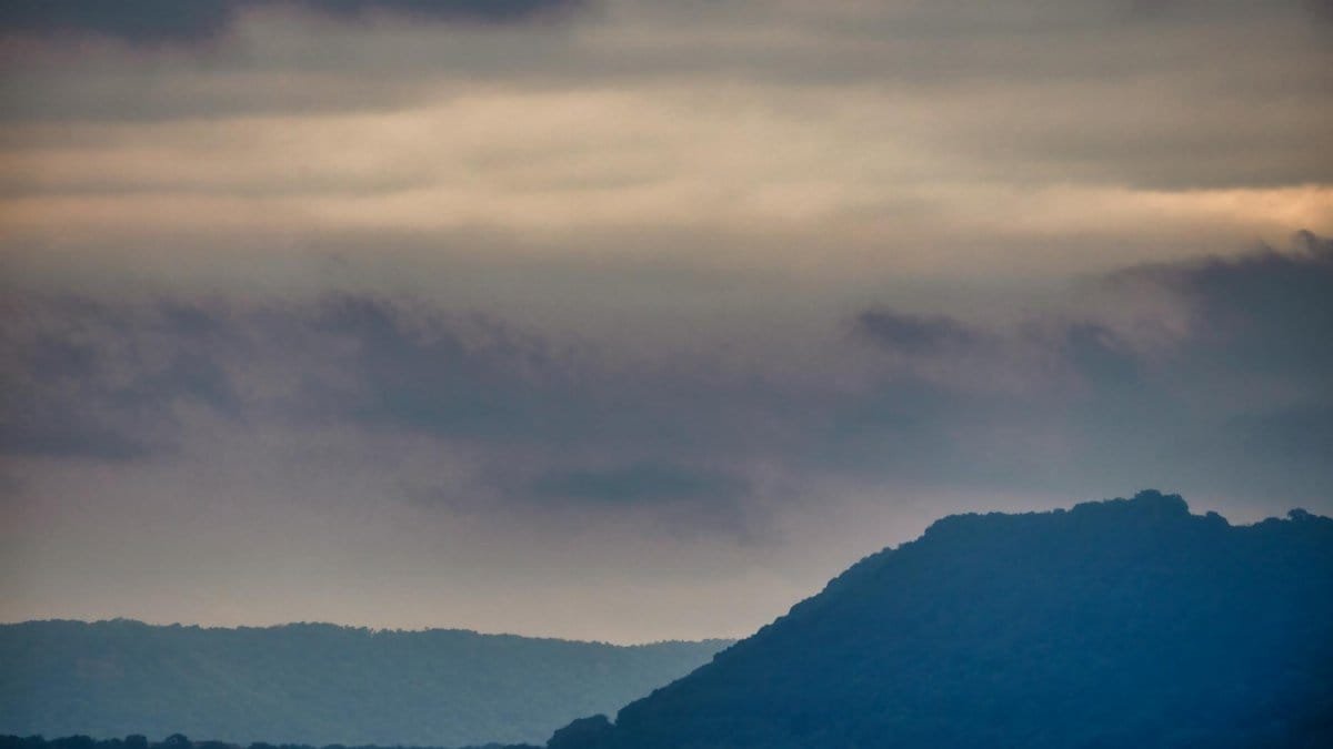 A tranquil overcast view of Lake City, Minnesota, featuring peaceful hills and cloudy skies.