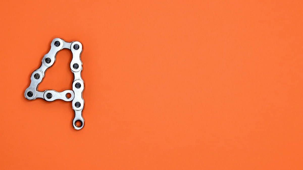 A creative design of the number four formed with a metal chain against an orange background, offering ample copy space.