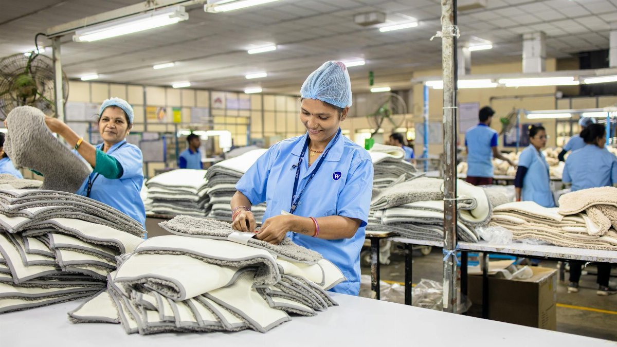 Workers in a textile factory sorting piles of fabric, highlighting teamwork and industry in garment production.
