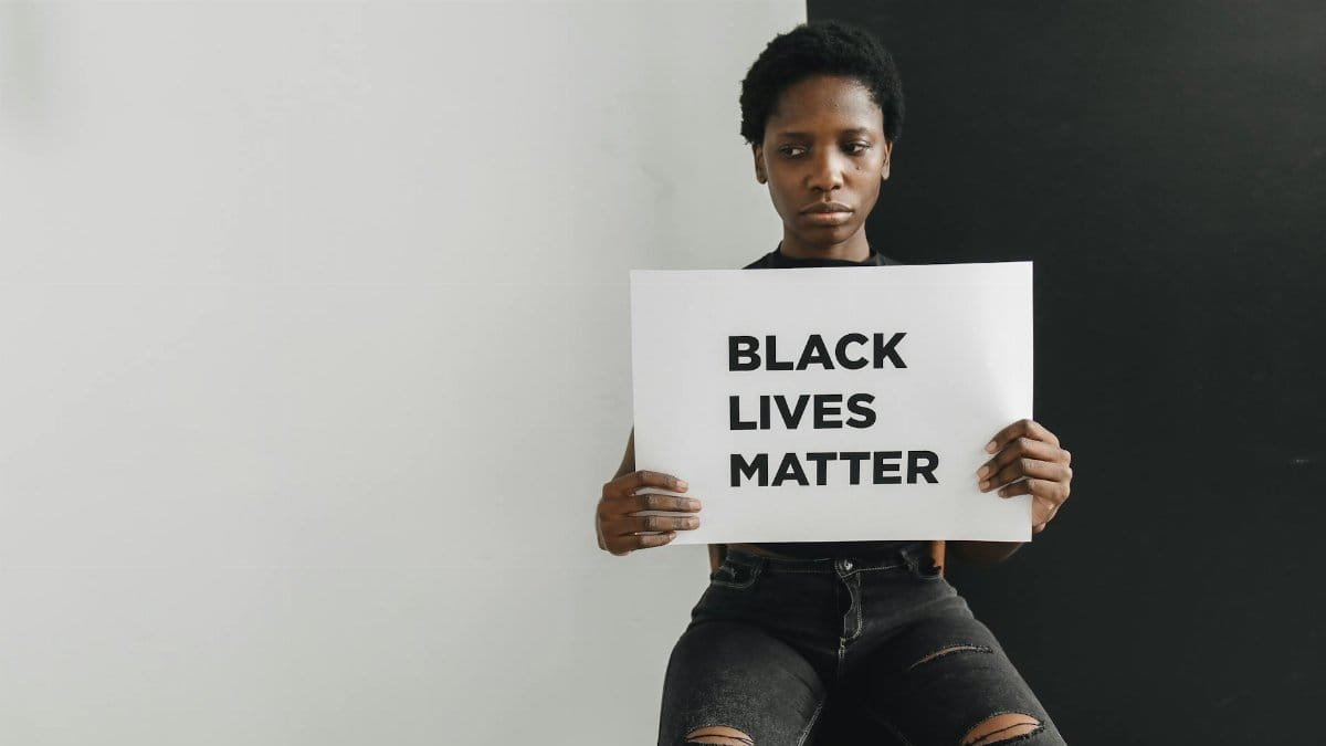 A person holding a Black Lives Matter sign emphasizing racial equality and justice.