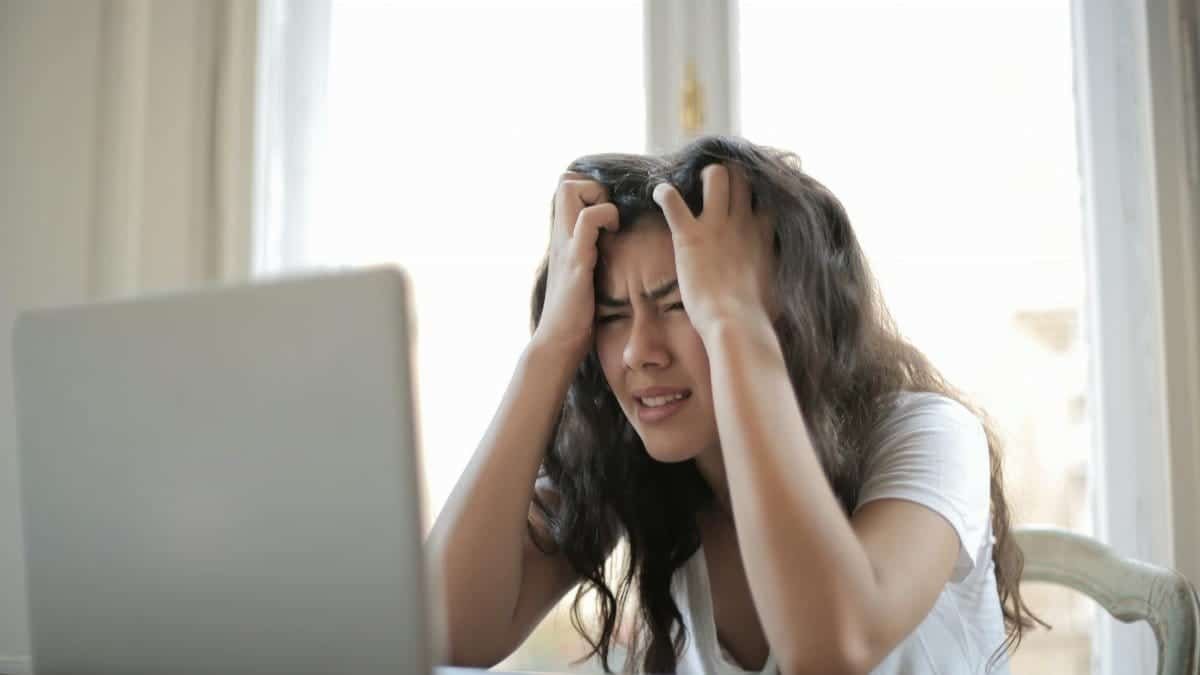 Frustrated woman struggling with remote work stress and digital challenges indoors.