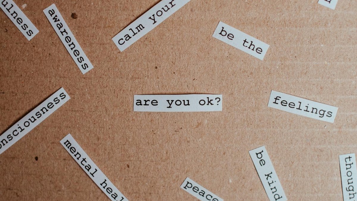 Cut-out words promoting mental health awareness on cardboard background.