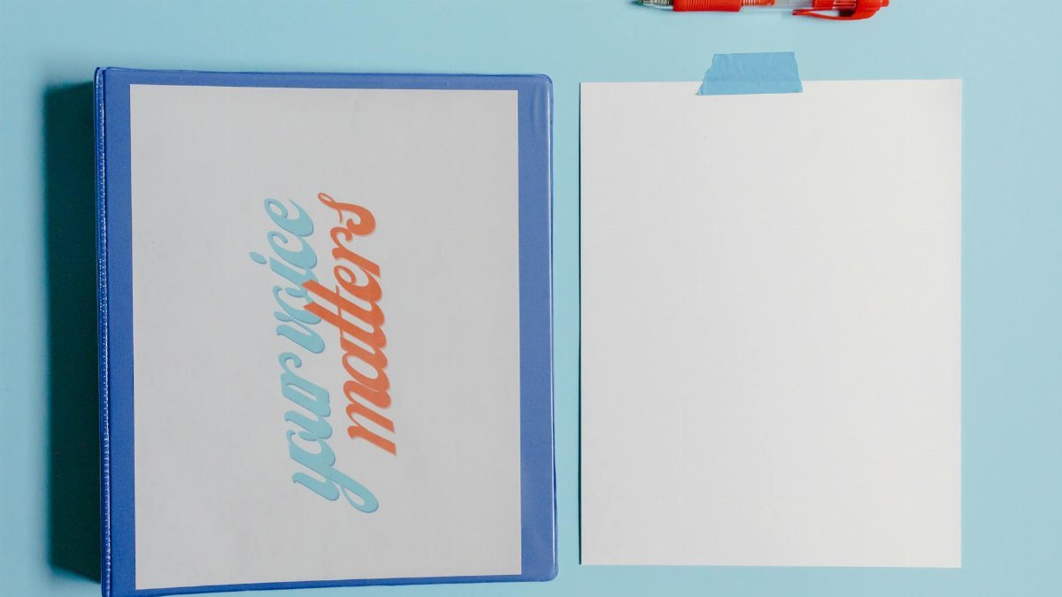 Your Voice Matters binder with blank paper and pen on blue background.