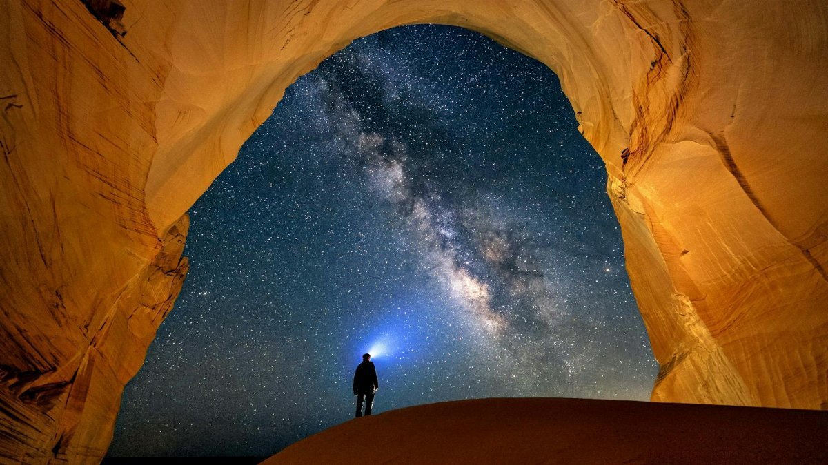 Explore the breathtaking view of the Milky Way through a natural arch in Kanab, Utah.