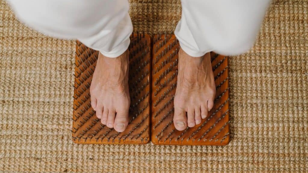 Close-up of feet on an acupressure board for holistic wellness practice.