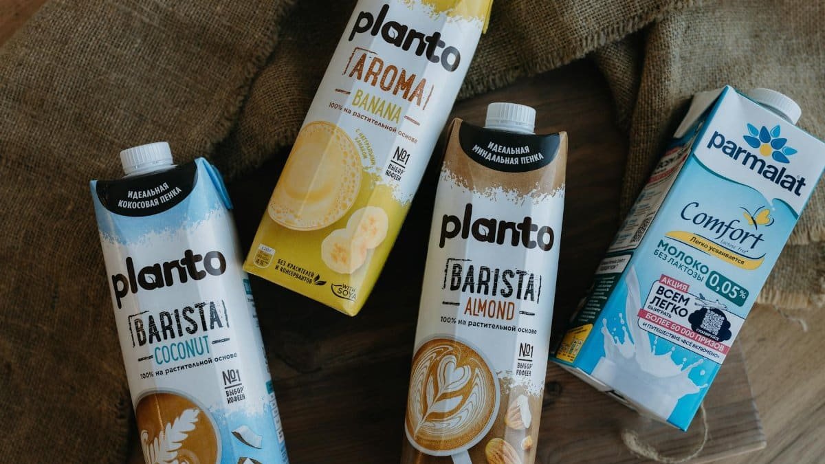 Assorted plant-based milk cartons including almond, coconut, and banana varieties.
