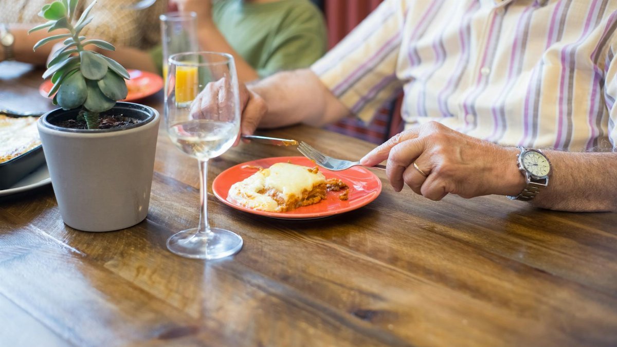 An intimate family meal with homemade lasagna served on a colorful plate, creating a cozy atmosphere.
