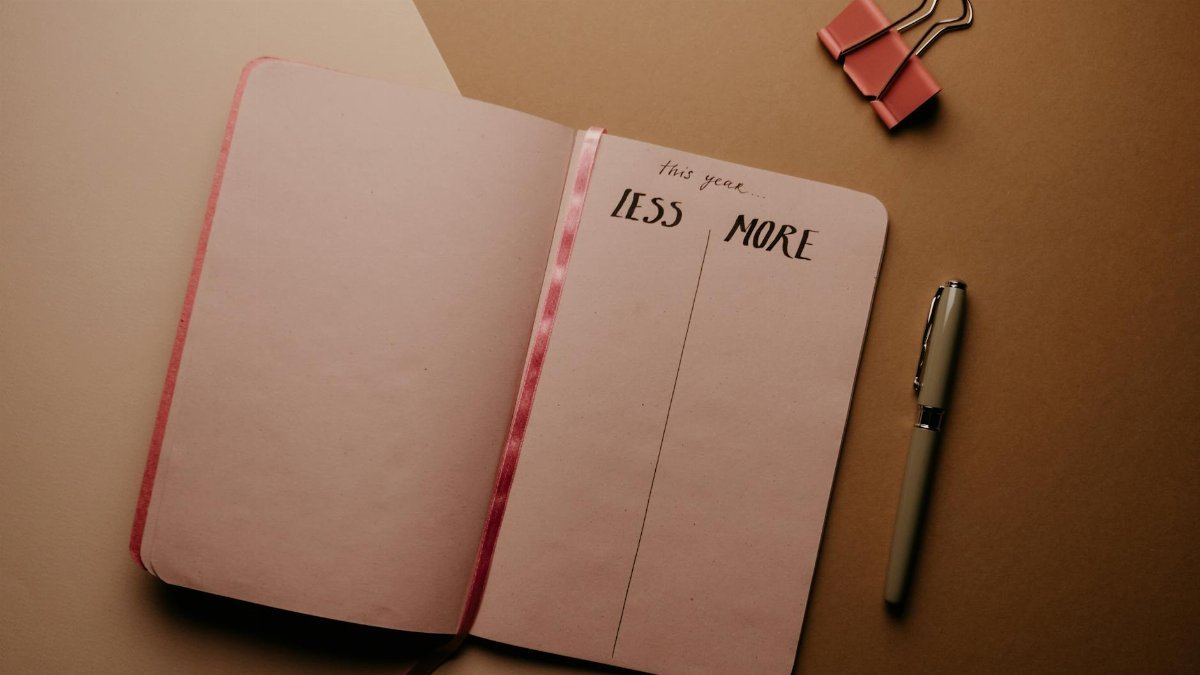 Open notebook for setting New Year resolutions with a pen on a brown background.